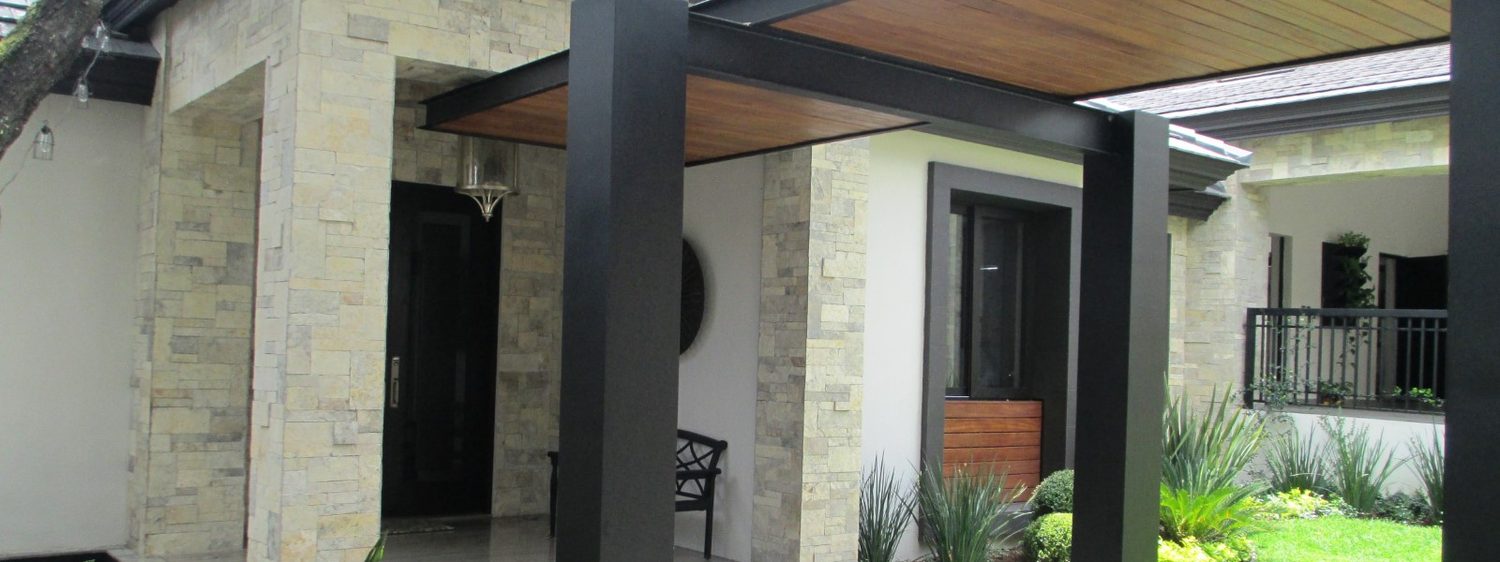 Terraza con pérgola de madera y columnas de piedra