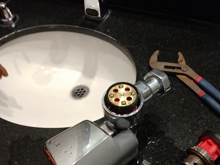 Trabajo de plomería en un lavabo comercial